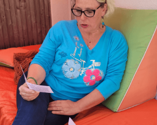 Photo d'une femme blonde avec des lunettes qui découvre un carnet Astro Adulte.